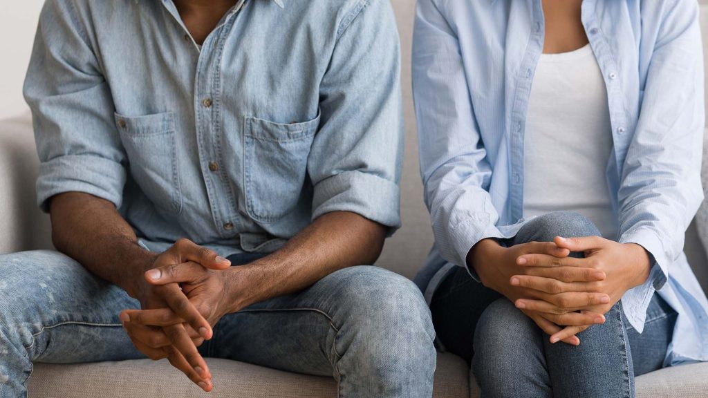 Man and woman sitting on couch at marital counselor's office